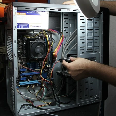 Computer repair man repairing a desktop pc with the cover off